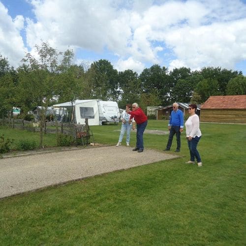 Gasten spelen jeu de boules op het terrein
