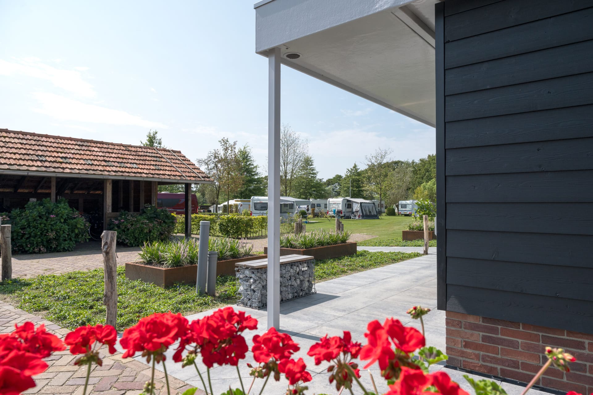 Rode geraniums voor het moderne sanitairgebouw van de camping